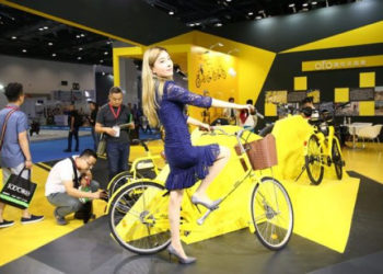 Une jeune femme essaie un vélo Ofo lors d'une exposition à Pékin