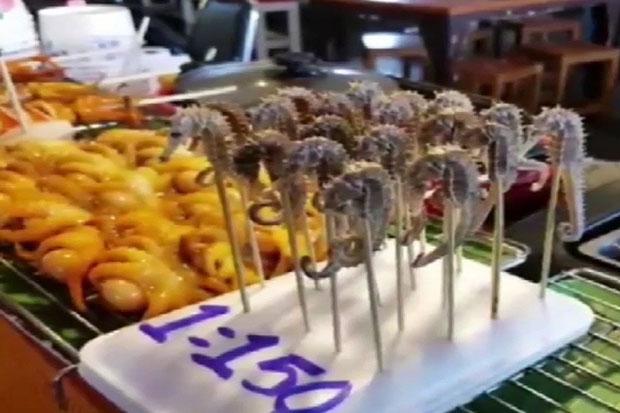 À Pattaya, un vendeur vendait des hippocampes grillés sur un marché